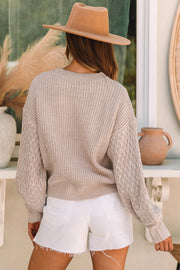 Cable knit drop shoulder sweater showing textured cable detailing on long sleeves
