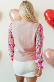 Floral patchwork knit top featuring lantern sleeves and smocked cuffs
