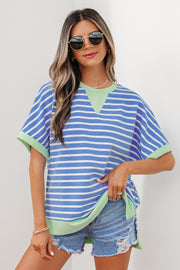 Woman wearing sky blue and white striped loose short sleeve top with light green contrast trim