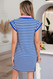 Back view of a woman wearing a blue and white striped short dress with pink contrast collar and flutter sleeves