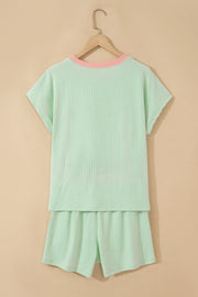 Mint green ribbed short set with pink trim on neckline, shown from back on hanger