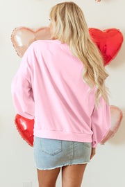 Oversized pink pullover sweatshirt with sweet embroidered bow accents