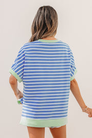 Back view of a person wearing a sky blue and white striped loose short sleeve top with light green contrast trim
