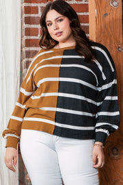 Plus size colorblock striped patchwork loose top in mustard and black, worn by a model against brick and wood background