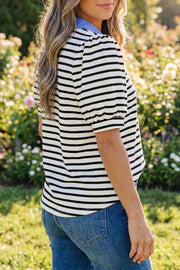 Black and white striped short puff sleeve polo collar blouse worn by a person outdoors