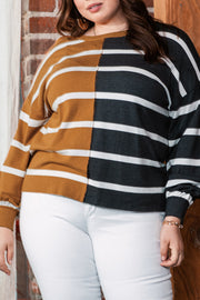 Plus size colorblock striped patchwork loose top in mustard and black, worn by a person against a brick wall