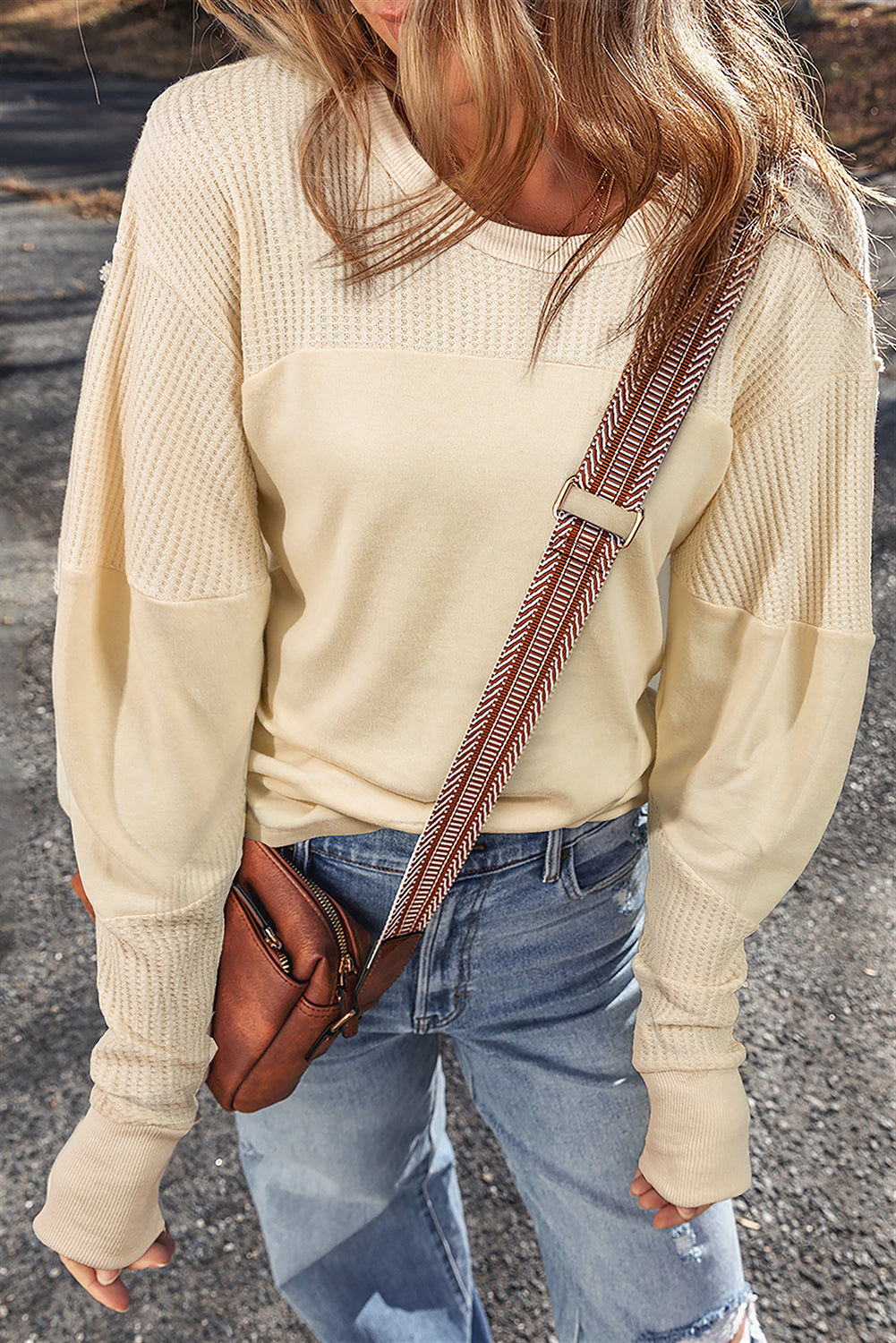 Beige thermal knit patchwork long sleeve top with exposed seams and crew neck