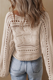 Cropped cable knit sweater showing openwork cut-out texture detail