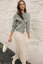 Gray bow front cardigan worn open to reveal button-up detail