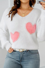 White fuzzy V-neck sweater with pearl-beaded heart pattern