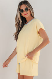 Model wearing yellow ribbed short set with light blue trim, side angle