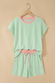 Mint green ribbed short set with pink trim and drawstring waist, hanging on wooden hanger