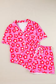 Pink short sleeve pajama set with red flower print, shown flat on neutral surface