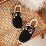 Black embroidered straw flat mules with woven upper