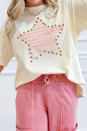 Beige cotton jersey top with pink star print and gold studs, worn by a person in pink pants