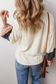 Beige patchwork blouse showing relaxed shift silhouette and long sleeves