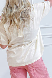 Back view of a beige cotton jersey top with stud detail, worn with pink pants