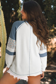 Floral patchwork waffle knit top showing textured long raglan sleeves
