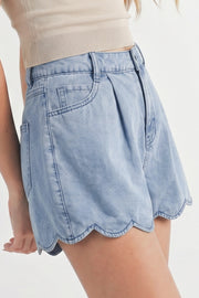 Light blue denim shorts with scalloped hem, shown from back on model