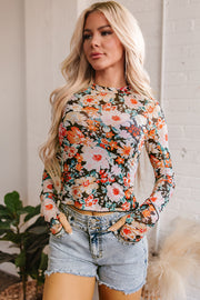Orange floral crop top styled with high-waisted jeans