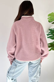 Fuchsia plush sweatshirt showing zipped pockets and loose fit