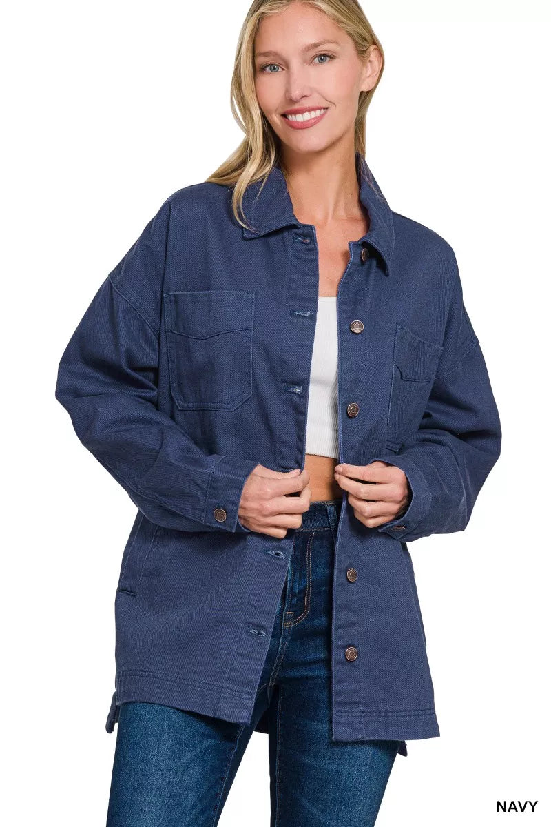 Woman wearing navy oversized cotton shacket with button-front and collar, unbuttoned over white top and jeans