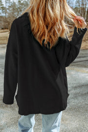Black shacket showing two chest flap pockets and button front